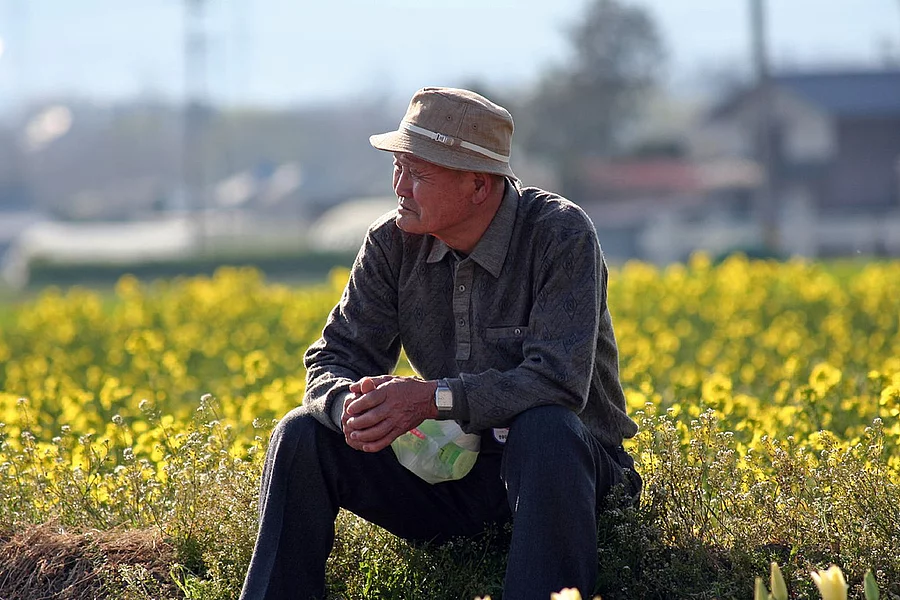 畑に座る老年男性